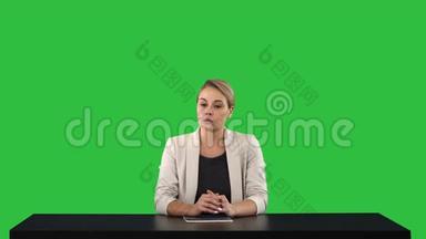 一个女新闻播报员呈现新闻，在她身后的绿色屏幕上添加你自己的文本或图像屏幕，Chroma键。